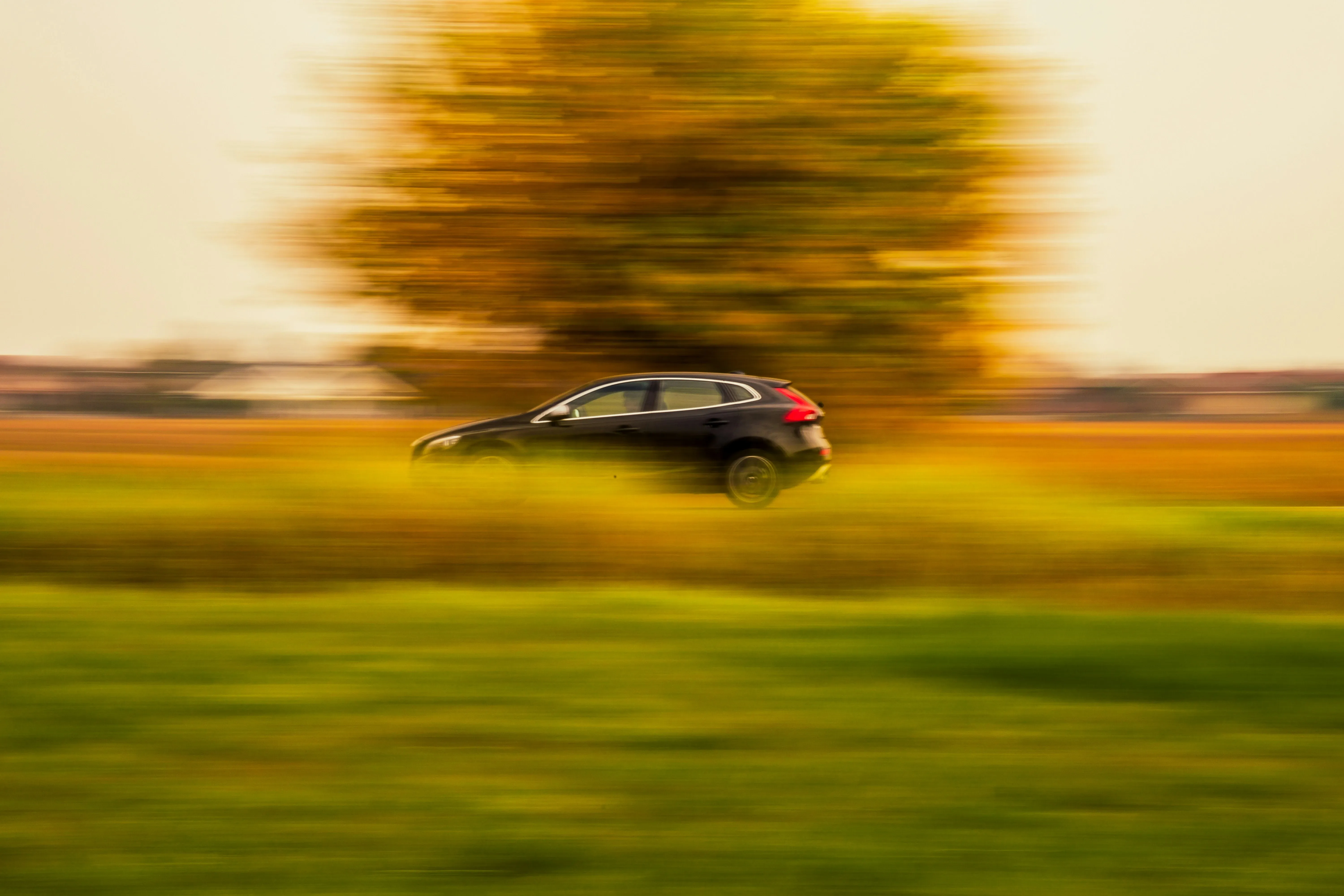 A car speeding down a small road in Italy