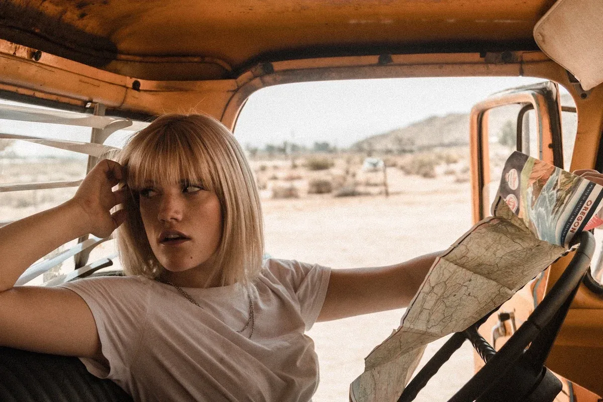 A woman in a car with a paper map
